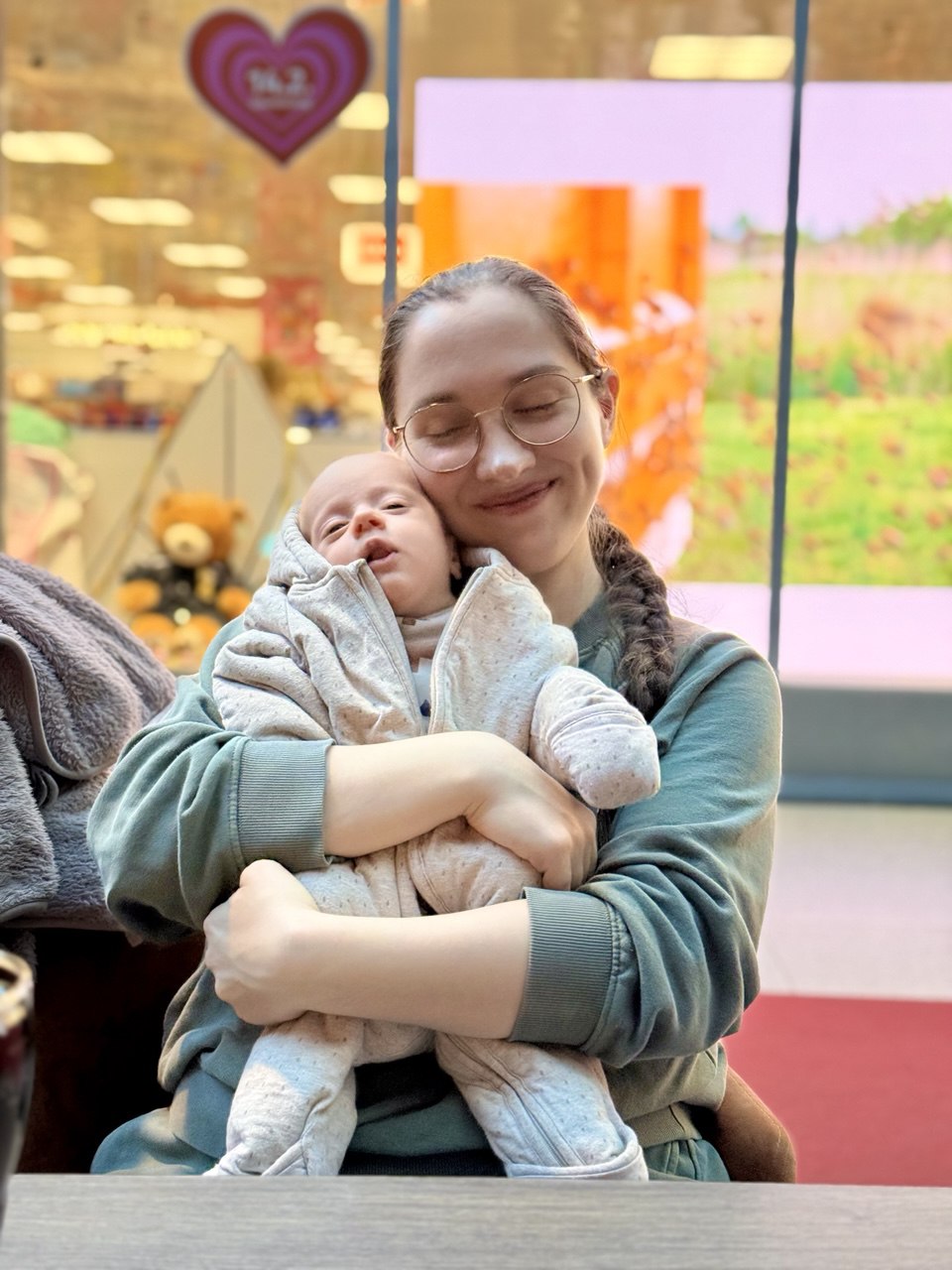 Die Mutter hält ihr schlafendes Kind eng und zärtlich im Arm.